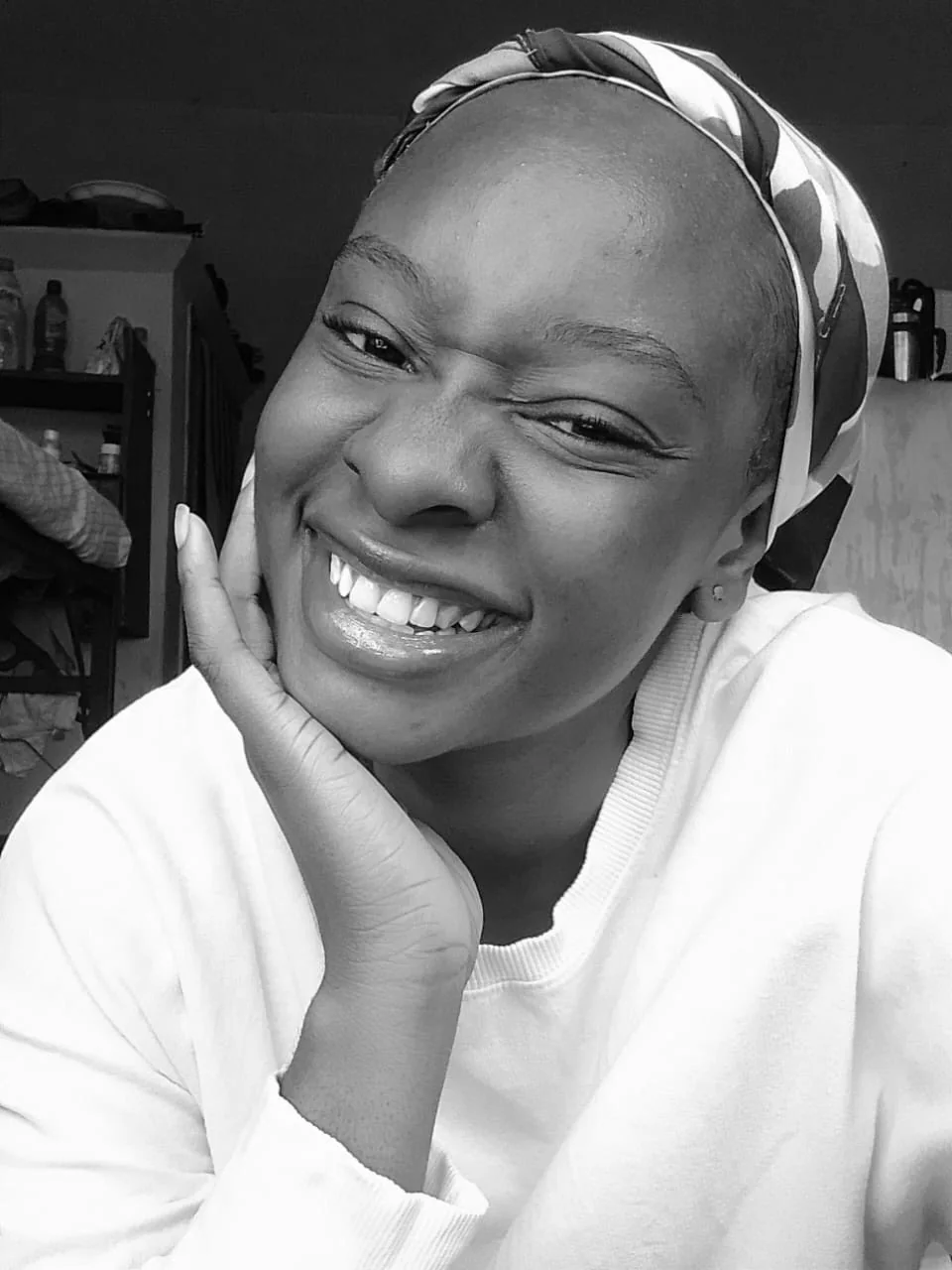 Black-and-white photo of Peace laughing, chin resting on her hand