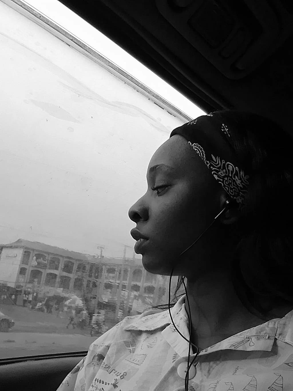 Black-and-white photo of Peace looking out of a car window