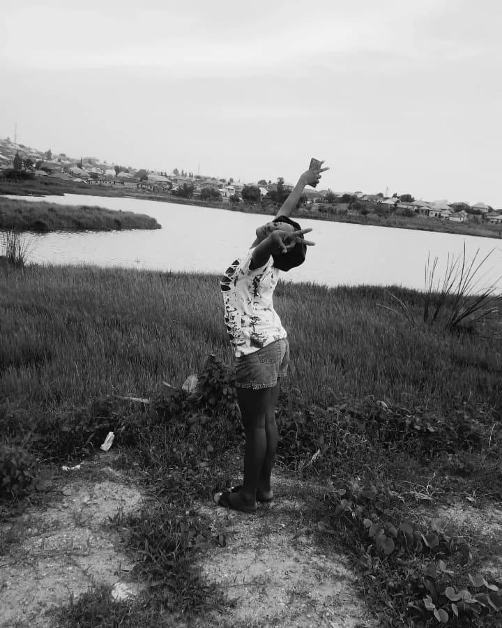 Black-and-white photo of Peace by the water, one arm raised to the sky