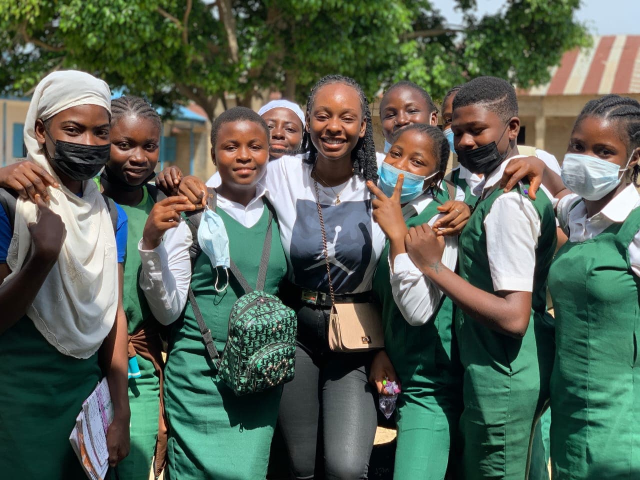 Peace smiling with a group of schoolgirls in green uniforms