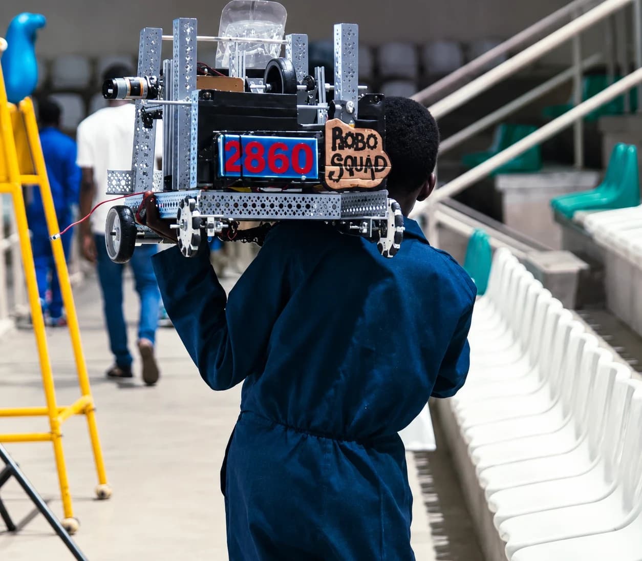 A student carries the Robo Squad robot through the arena at the National Robotics Championship 2026