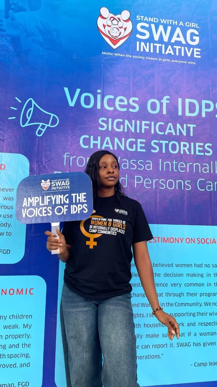 Peace holding a placard at the Voices of IDPs exhibition