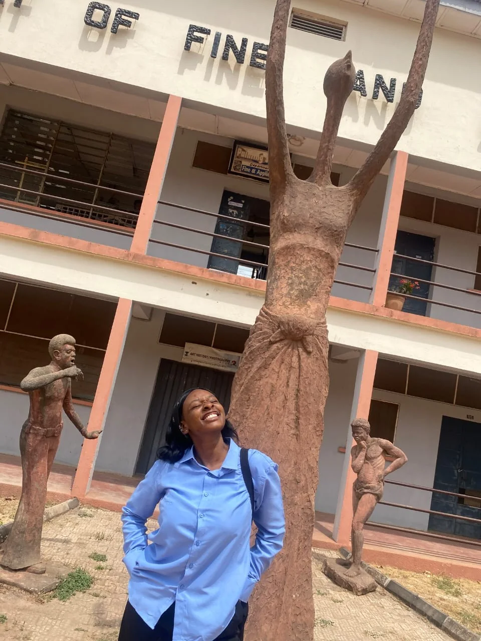 Peace beside a sculpture outside the Faculty of Fine Arts